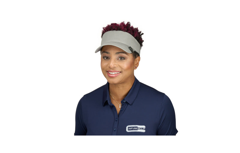 Load image into Gallery viewer, InfusenClip Inventor Robyn James wearing a visor with a black InfusenClip attached. The InfusenClip is a vanilla scented clip that helps to effectively keep bugs away without the use of DEET. 
